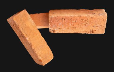 Yığındaki üç çatlamış kırmızı ya da turuncu tuğlanın yan görünümü kırpma yolu ile siyah arkaplanda izole edilmiştir..