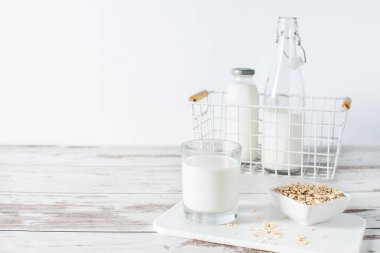 Yulaf gevreğinden yapılmış ev yapımı süt. Beyaz tahta masada vejetaryen yulaf sütü..