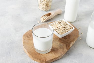 Yulaf gevreğinden yapılmış ev yapımı süt. Gri beton masada vejetaryen yulaf sütü.