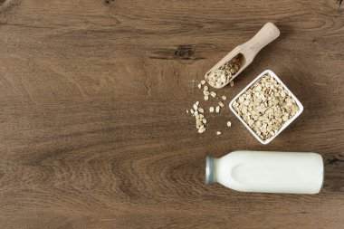 Yulaf gevreğinden yapılmış ev yapımı süt. Tahta masa manzaralı vejetaryen yulaf sütü.