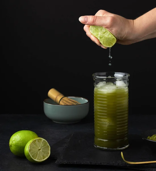 Mujer Mano Exprimiendo Cal Vidrio Con Matcha Verde Hielo Sobre — Foto de Stock