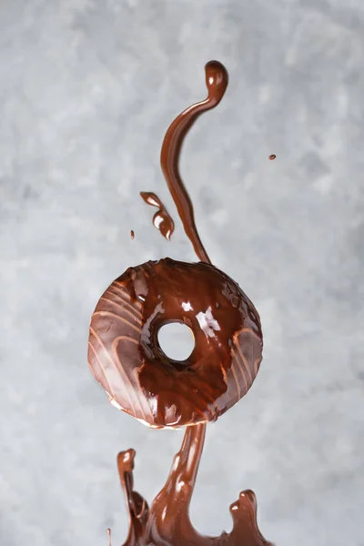 Fliegender Donut Mit Spritzender Schokoladenglasur Vor Grauem Hintergrund Werbung Für — Stockfoto