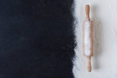 Siyah yüzey üzerinde yuvarlak toplu iğne manzaralı buğday unu. Tasarımınız için fırın arkaplanı.