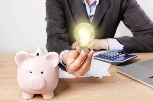 Businesswoman Holding Lightbulb Piggy Bank Calculator Desk Saving Energy Concept — Stockfoto