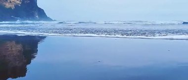 Mavi deniz manzarası ve uçurumun kenarında yumuşak dalgalar olan tropikal plaj.