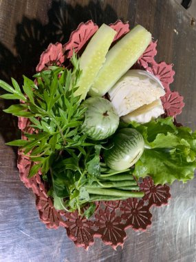 Dilimlenmiş salatalık, fesleğen, patlıcan, lahana ve ahşap tabakta uzun fasulyeler dahil çeşitli taze sebzeler. Sağlıklı gıda konsepti.