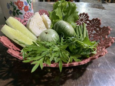 Dilimlenmiş salatalık, fesleğen, patlıcan, lahana ve ahşap tabakta uzun fasulyeler dahil çeşitli taze sebzeler. Sağlıklı gıda konsepti.