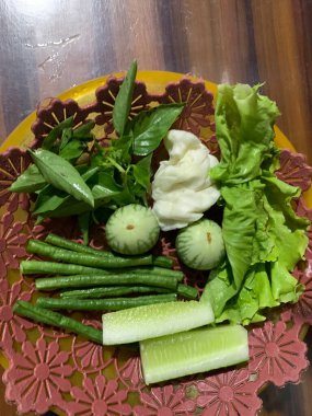 Dilimlenmiş salatalık, fesleğen, patlıcan, lahana ve ahşap tabakta uzun fasulyeler dahil çeşitli taze sebzeler. Sağlıklı gıda konsepti.