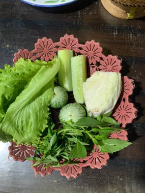 Dilimlenmiş salatalık, fesleğen, patlıcan, lahana ve ahşap tabakta uzun fasulyeler dahil çeşitli taze sebzeler. Sağlıklı gıda konsepti.