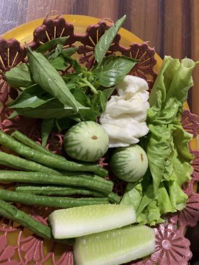 Dilimlenmiş salatalık, fesleğen, patlıcan, lahana ve ahşap tabakta uzun fasulyeler dahil çeşitli taze sebzeler. Sağlıklı gıda konsepti.