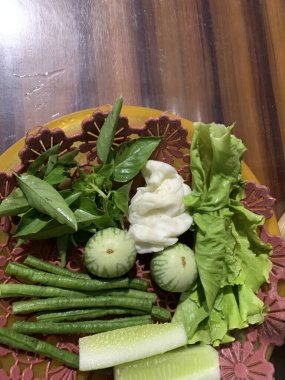 Dilimlenmiş salatalık, fesleğen, patlıcan, lahana ve ahşap tabakta uzun fasulyeler dahil çeşitli taze sebzeler. Sağlıklı gıda konsepti.