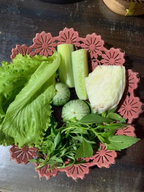 Dilimlenmiş salatalık, fesleğen, patlıcan, lahana ve ahşap tabakta uzun fasulyeler dahil çeşitli taze sebzeler. Sağlıklı gıda konsepti.