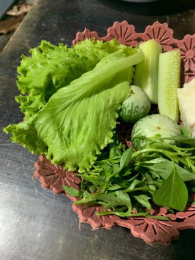 Dilimlenmiş salatalık, fesleğen, patlıcan, lahana ve ahşap tabakta uzun fasulyeler dahil çeşitli taze sebzeler. Sağlıklı gıda konsepti.