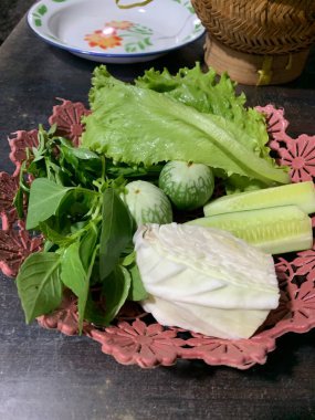 Dilimlenmiş salatalık, fesleğen, patlıcan, lahana ve ahşap tabakta uzun fasulyeler dahil çeşitli taze sebzeler. Sağlıklı gıda konsepti.