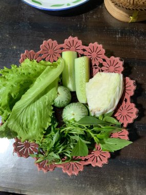 Dilimlenmiş salatalık, fesleğen, patlıcan, lahana ve ahşap tabakta uzun fasulyeler dahil çeşitli taze sebzeler. Sağlıklı gıda konsepti.