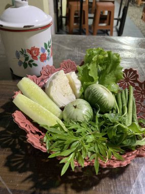 Dilimlenmiş salatalık, fesleğen, patlıcan, lahana ve ahşap tabakta uzun fasulyeler dahil çeşitli taze sebzeler. Sağlıklı gıda konsepti.