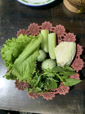 Dilimlenmiş salatalık, fesleğen, patlıcan, lahana ve ahşap tabakta uzun fasulyeler dahil çeşitli taze sebzeler. Sağlıklı gıda konsepti.