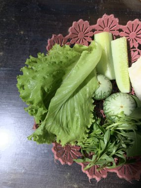 Dilimlenmiş salatalık, fesleğen, patlıcan, lahana ve ahşap tabakta uzun fasulyeler dahil çeşitli taze sebzeler. Sağlıklı gıda konsepti.