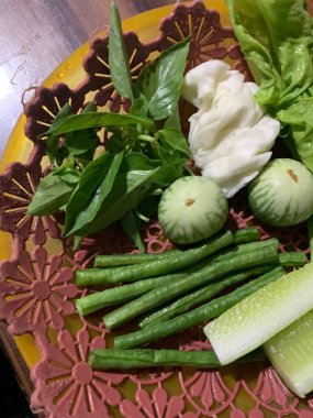 Dilimlenmiş salatalık, fesleğen, patlıcan, lahana ve ahşap tabakta uzun fasulyeler dahil çeşitli taze sebzeler. Sağlıklı gıda konsepti.