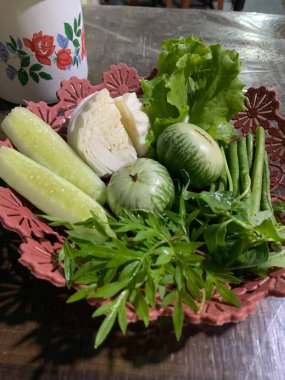 Dilimlenmiş salatalık, fesleğen, patlıcan, lahana ve ahşap tabakta uzun fasulyeler dahil çeşitli taze sebzeler. Sağlıklı gıda konsepti.