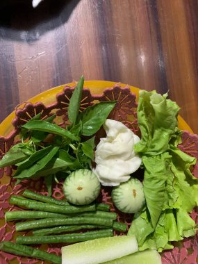 Dilimlenmiş salatalık, fesleğen, patlıcan, lahana ve ahşap tabakta uzun fasulyeler dahil çeşitli taze sebzeler. Sağlıklı gıda konsepti.