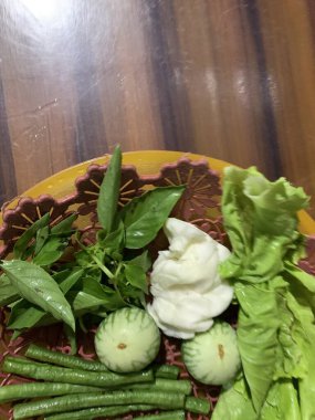 Dilimlenmiş salatalık, fesleğen, patlıcan, lahana ve ahşap tabakta uzun fasulyeler dahil çeşitli taze sebzeler. Sağlıklı gıda konsepti.