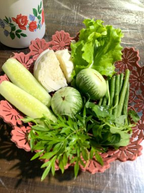 Dilimlenmiş salatalık, fesleğen, patlıcan, lahana ve ahşap tabakta uzun fasulyeler dahil çeşitli taze sebzeler. Sağlıklı gıda konsepti.