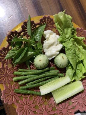 Dilimlenmiş salatalık, fesleğen, patlıcan, lahana ve ahşap tabakta uzun fasulyeler dahil çeşitli taze sebzeler. Sağlıklı gıda konsepti.