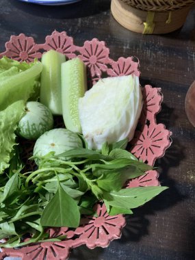 Dilimlenmiş salatalık, fesleğen, patlıcan, lahana ve ahşap tabakta uzun fasulyeler dahil çeşitli taze sebzeler. Sağlıklı gıda konsepti.