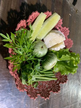 Dilimlenmiş salatalık, fesleğen, patlıcan, lahana ve ahşap tabakta uzun fasulyeler dahil çeşitli taze sebzeler. Sağlıklı gıda konsepti.