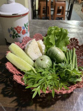 Dilimlenmiş salatalık, fesleğen, patlıcan, lahana ve ahşap tabakta uzun fasulyeler dahil çeşitli taze sebzeler. Sağlıklı gıda konsepti.