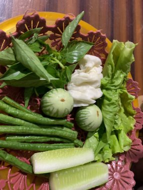 Dilimlenmiş salatalık, fesleğen, patlıcan, lahana ve ahşap tabakta uzun fasulyeler dahil çeşitli taze sebzeler. Sağlıklı gıda konsepti.