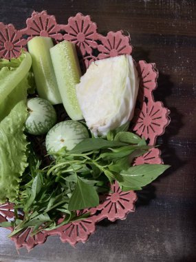 Dilimlenmiş salatalık, fesleğen, patlıcan, lahana ve ahşap tabakta uzun fasulyeler dahil çeşitli taze sebzeler. Sağlıklı gıda konsepti.