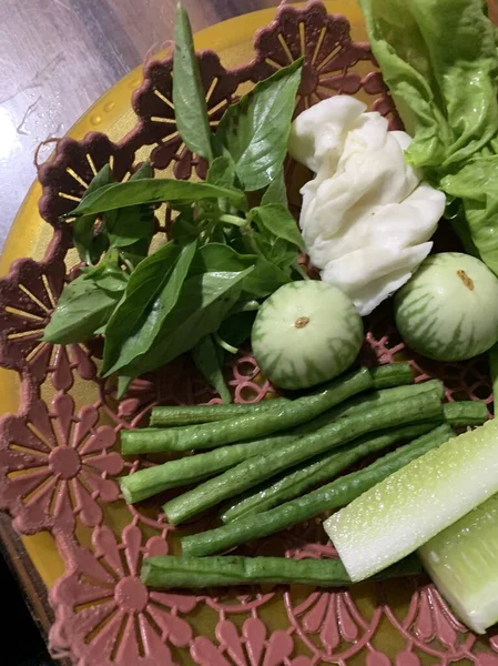 Dilimlenmiş salatalık, fesleğen, patlıcan, lahana ve ahşap tabakta uzun fasulyeler dahil çeşitli taze sebzeler. Sağlıklı gıda konsepti.