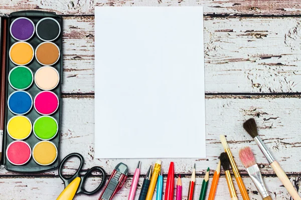 Un conjunto de papelería sobre fondo de madera, el lugar del artista — Foto de Stock