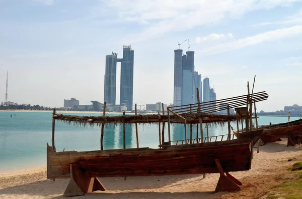 Старая лодка на фоне небоскребов в Абу-Даби — стоковое фото