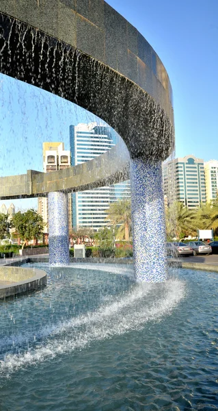 Der Brunnen auf dem Hintergrund von Wolkenkratzern in abu dhabi — Stockfoto