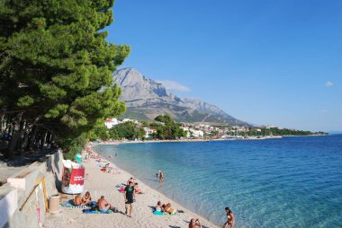 Baska Voda, Hırvatistan - 7 Eylül 2009: Turistler Adriyatik Denizi sahillerinde güneşleniyor ve yüzüyorlar