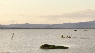 Günbatımında Gölde Tekneye Binen İnsanlar