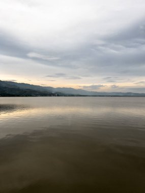 göl ve dağ bulutlu gökyüzü altında doğal görünümü