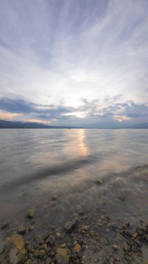 Bulutlu Gökyüzü ile Günbatımında Manzaralı Göl