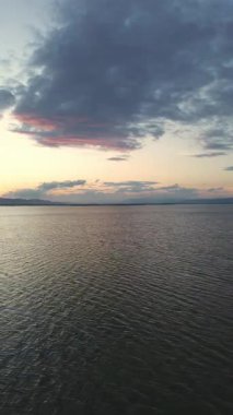 Bulutlu Gökyüzü ile Gün Batımında Serene Gölü