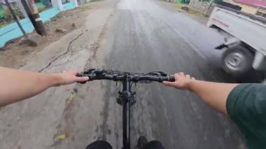 Islak yolda bisiklete binmek POV Vuruşu