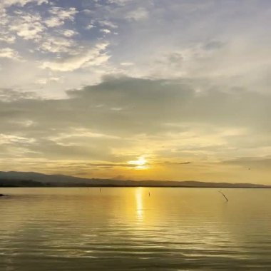 Sakin Göl 'ün Üzerinde Altın Gün Batımı. Limboto Gölü 'nde gün batımı manzarası, Gorontalo, Endonezya