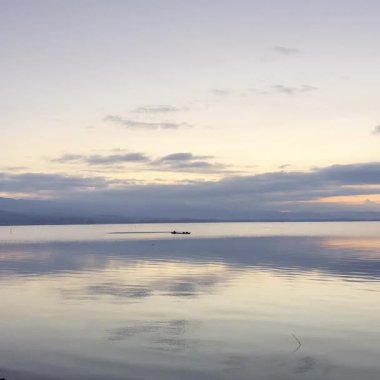Sunrise 'da tekneyle Göl Manzarası. Balıkçılar tahtadan yapılmış geleneksel balıkçı teknelerini kullanırlar..