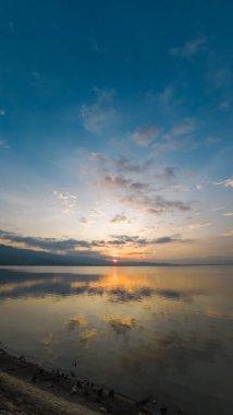 Sakin Su Üzerine Gün Doğumu Yansıması. Limboto Gölü 'nün sakin sularıyla gün batımı manzarası