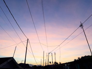 Elektrik kablolarıyla Günbatımı Gökyüzü Komşularının Üzerinde