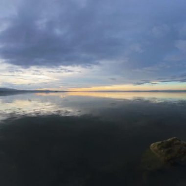 Gün batımında Sakin Göl Suyu Yansıtan Bulutlu Gökyüzü