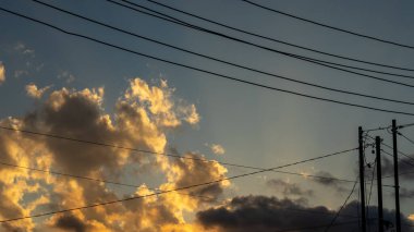 Bulutlar ve Güç Hatlarıyla Günbatımı Gökyüzü