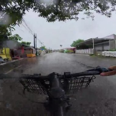 Kırsal bölgedeki Islak Sokak 'ta Bisiklete Binmek